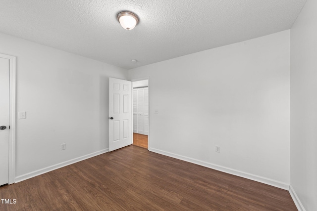 1308 Aspen Falls Ct, Willow Springs, NC 27592 - unfurnished bedroom with baseboards, a textured ceiling, and dark wood-style floors