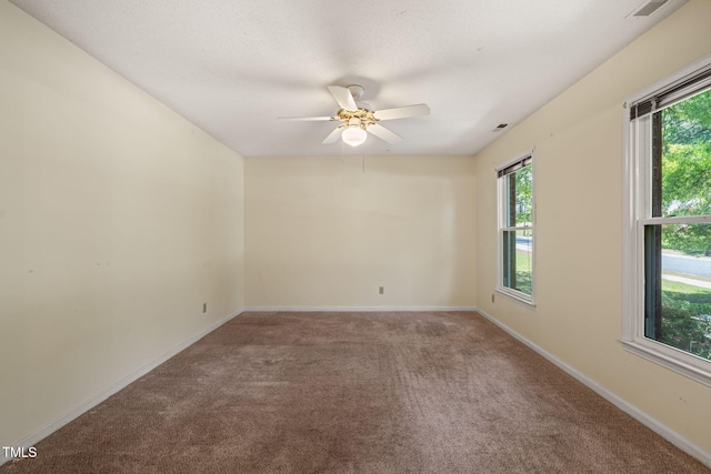 carpeted empty room featuring plenty of natural light, baseboards, and ceiling fan