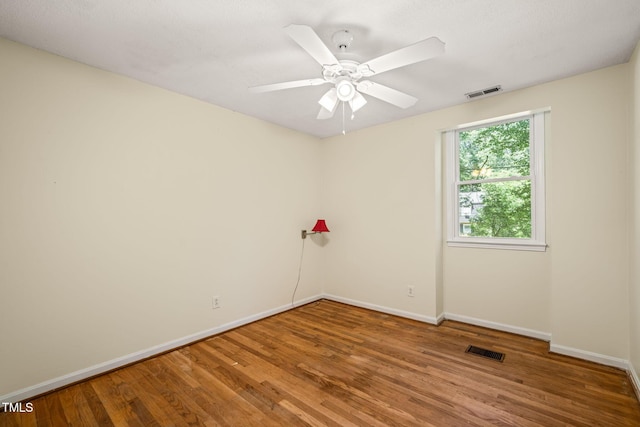 unfurnished room featuring baseboards, wood finished floors, and a ceiling fan