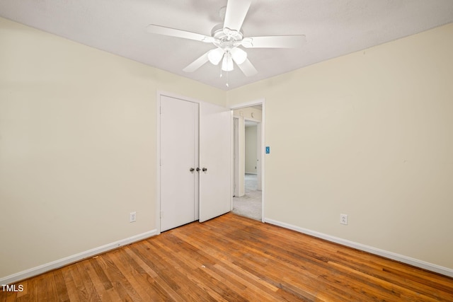 unfurnished bedroom with baseboards, wood finished floors, and ceiling fan