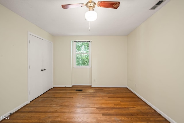 unfurnished bedroom with wood finished floors, baseboards, and ceiling fan