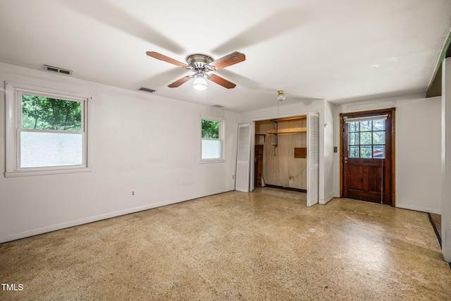 unfurnished bedroom featuring multiple windows, baseboards, and a ceiling fan