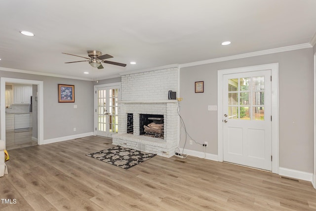 4610 Pinehurst Dr N, Wilson, NC 27896 - unfurnished living room with baseboards, crown molding, ceiling fan, a brick fireplace, and wood finished floors