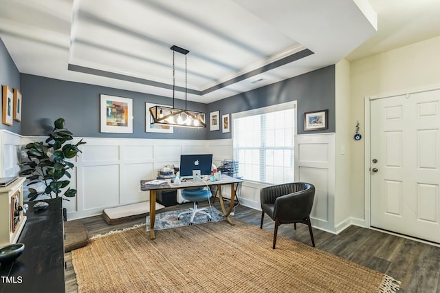 office area featuring a decorative wall, visible vents, a raised ceiling, dark wood-style floors, and wainscoting