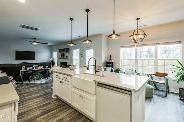 kitchen featuring a sink, dishwasher, plenty of natural light, visible vents, and dark wood-type flooring