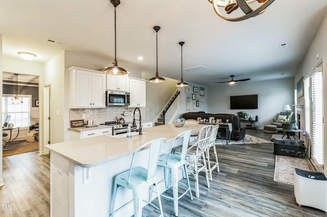 kitchen with light countertops, visible vents, a ceiling fan, appliances with stainless steel finishes, and a sink