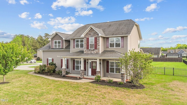 view of front of house featuring roof with shingles, a front yard, a porch, and fence