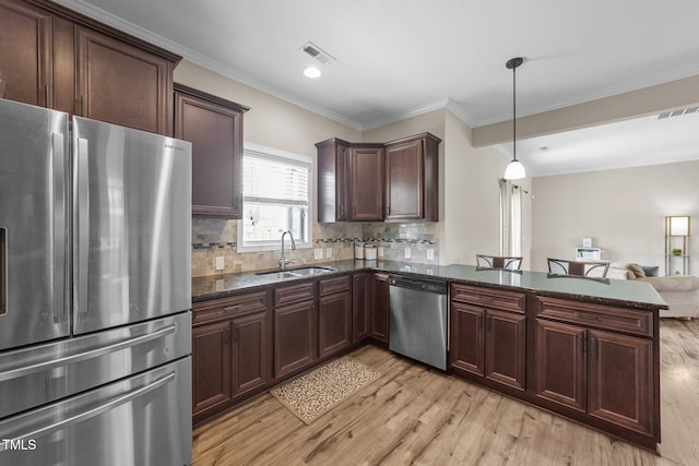 kitchen featuring a sink, visible vents, light wood finished floors, and stainless steel appliances