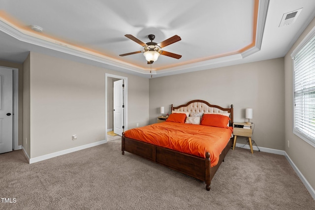 carpeted bedroom featuring a raised ceiling, baseboards, a ceiling fan, and visible vents