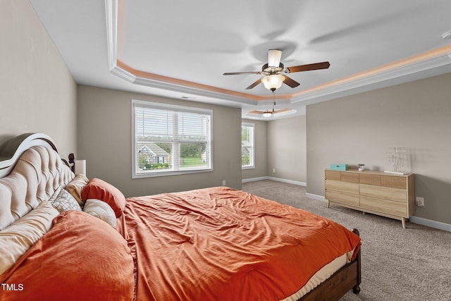bedroom with light colored carpet, baseboards, a ceiling fan, and a raised ceiling
