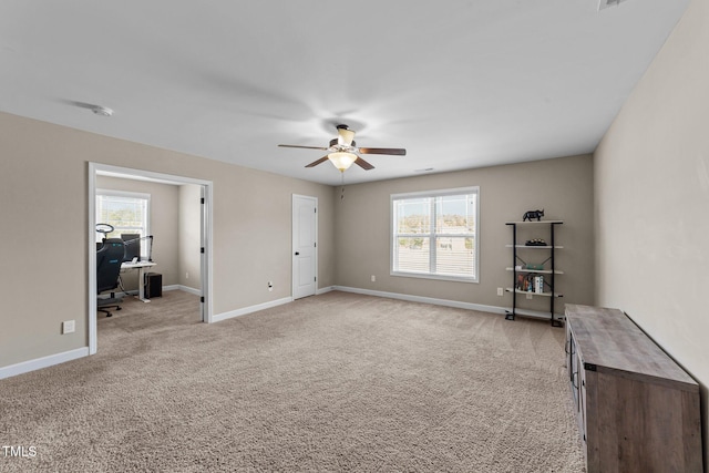 empty room featuring light carpet, ceiling fan, and baseboards