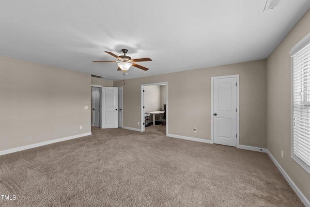 unfurnished bedroom featuring visible vents, baseboards, multiple windows, and carpet