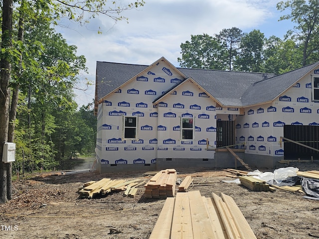 view of side of home featuring crawl space and roof with shingles