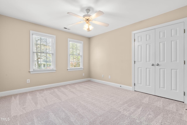 unfurnished bedroom with a closet, baseboards, a ceiling fan, visible vents, and carpet