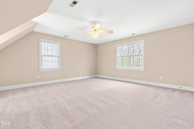 spare room featuring light carpet, baseboards, a ceiling fan, and visible vents