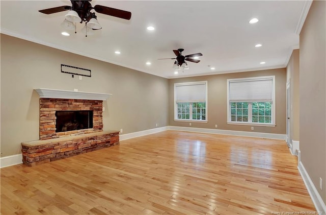 unfurnished living room featuring crown molding, baseboards, a fireplace, a ceiling fan, and light wood-style floors