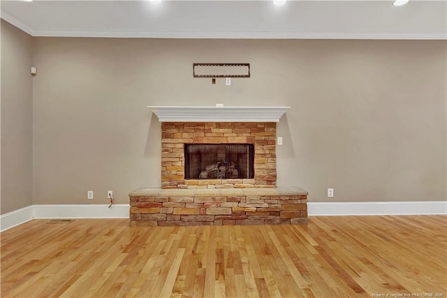 unfurnished living room with hardwood / wood-style floors, ornamental molding, baseboards, and a fireplace
