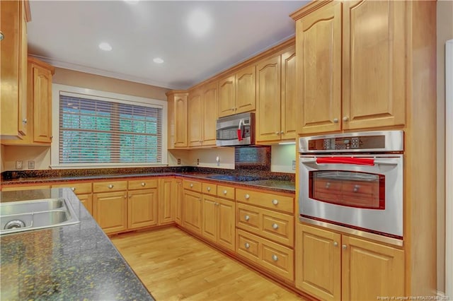 kitchen with ornamental molding, light brown cabinetry, a sink, light wood-style floors, and appliances with stainless steel finishes