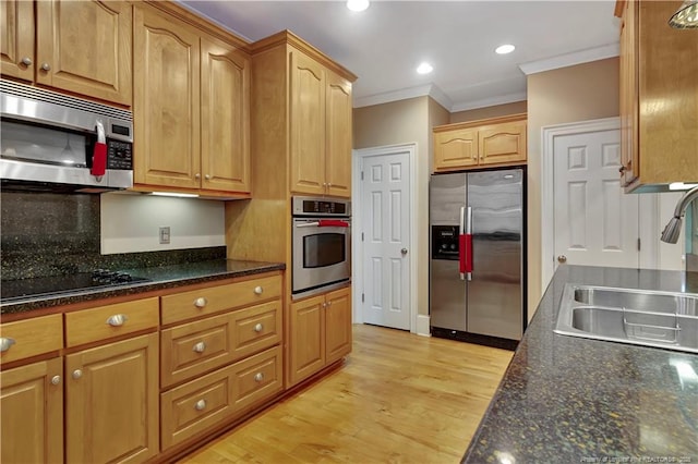kitchen featuring crown molding, a sink, light wood finished floors, appliances with stainless steel finishes, and recessed lighting