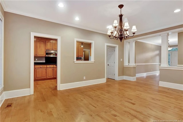 unfurnished dining area with light wood finished floors, baseboards, and crown molding