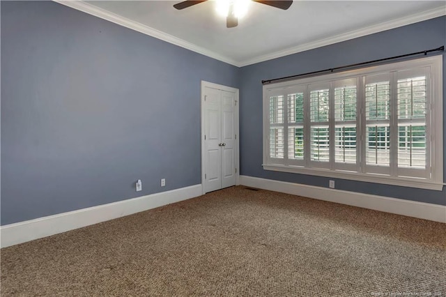 carpeted empty room featuring crown molding, baseboards, and ceiling fan
