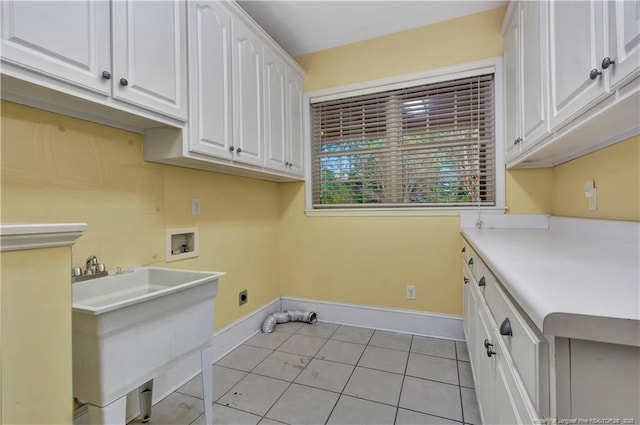 washroom featuring light tile patterned floors, baseboards, cabinet space, electric dryer hookup, and washer hookup