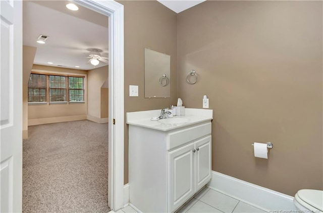 bathroom featuring tile patterned floors, toilet, vanity, baseboards, and ceiling fan