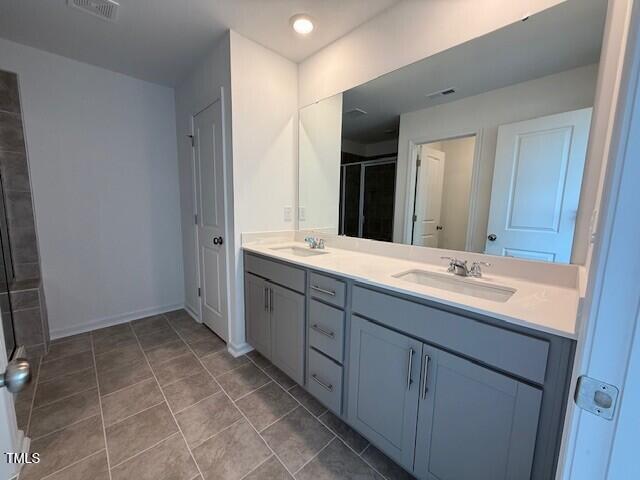 237 Shingle Oak Rd, Wake Forest, NC 27587 - bathroom with double vanity, a stall shower, and tile patterned flooring