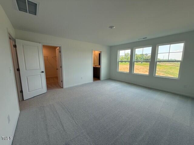 237 Shingle Oak Rd, Wake Forest, NC 27587 - unfurnished bedroom featuring carpet, ensuite bath, and a spacious closet