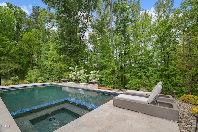 325 Forest Bridge Rd, Youngsville, NC 27596 - view of swimming pool featuring a patio, an in-ground hot tub, and a wooded view