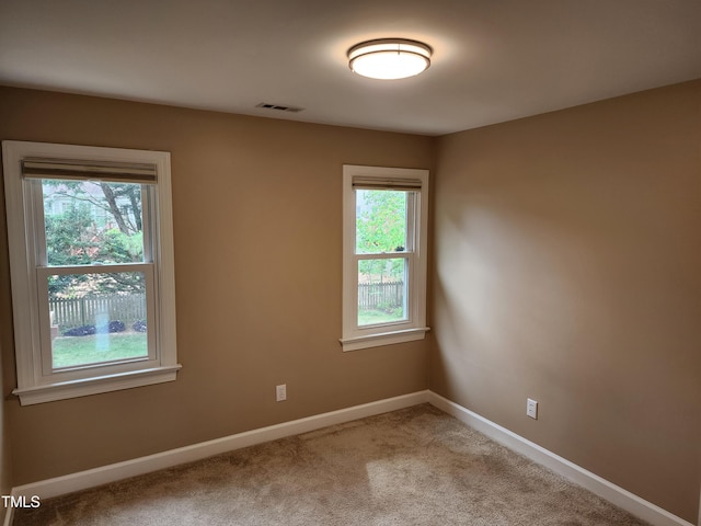 carpeted empty room with baseboards