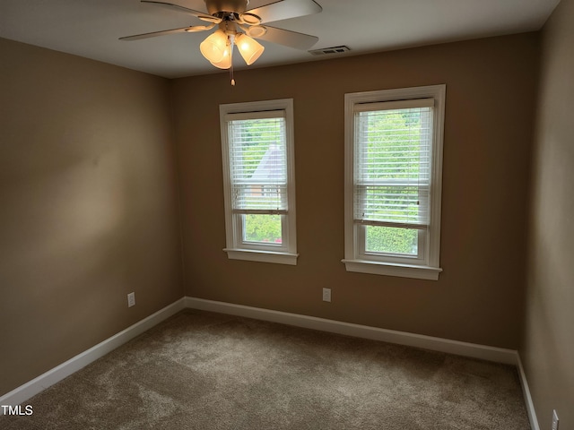 carpeted spare room with baseboards and a ceiling fan