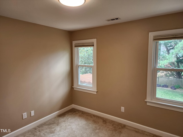 unfurnished room with plenty of natural light, baseboards, and carpet flooring
