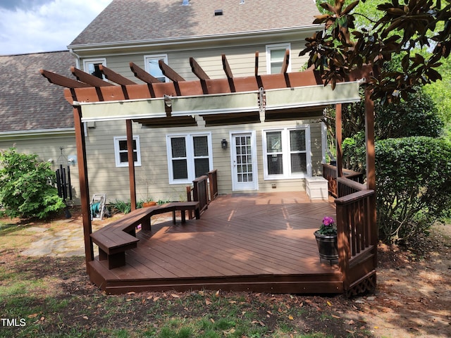 back of property with a shingled roof, a pergola, and a wooden deck