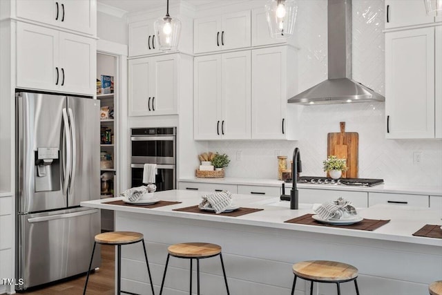 7616 Hasentree Way, Wake Forest, NC 27587 - kitchen with wall chimney range hood, white cabinets, appliances with stainless steel finishes, a breakfast bar, and light countertops