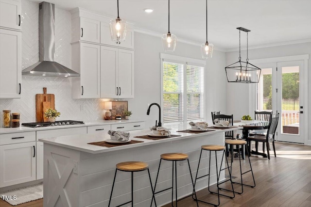 7616 Hasentree Way, Wake Forest, NC 27587 - kitchen featuring crown molding, stainless steel gas cooktop, light countertops, wall chimney exhaust hood, and tasteful backsplash