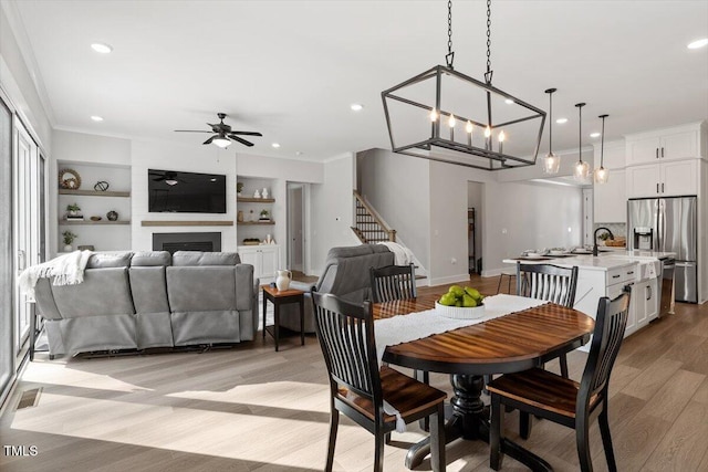 7616 Hasentree Way, Wake Forest, NC 27587 - dining room with ceiling fan, light wood-style floors, a large fireplace, stairs, and recessed lighting