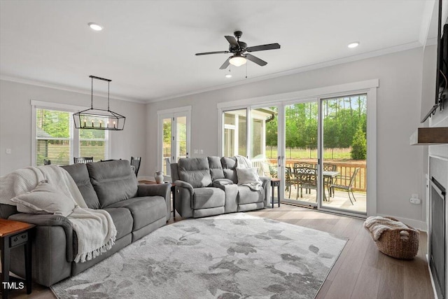 7616 Hasentree Way, Wake Forest, NC 27587 - living room with crown molding, ceiling fan with notable chandelier, recessed lighting, and wood finished floors