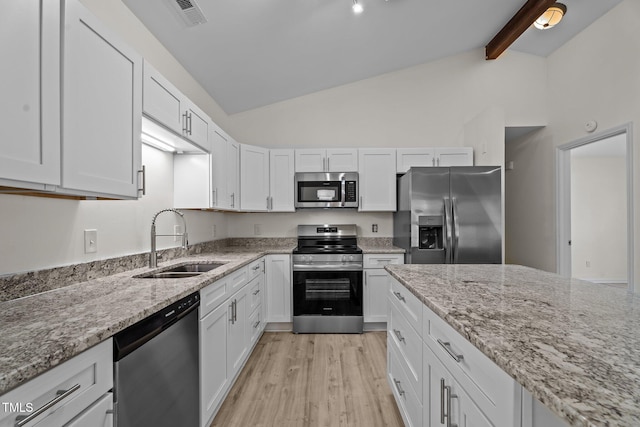 2941 Golden Oak Ct, Raleigh, NC 27603 - kitchen featuring white cabinets, lofted ceiling with beams, a sink, stainless steel appliances, and light wood-style flooring