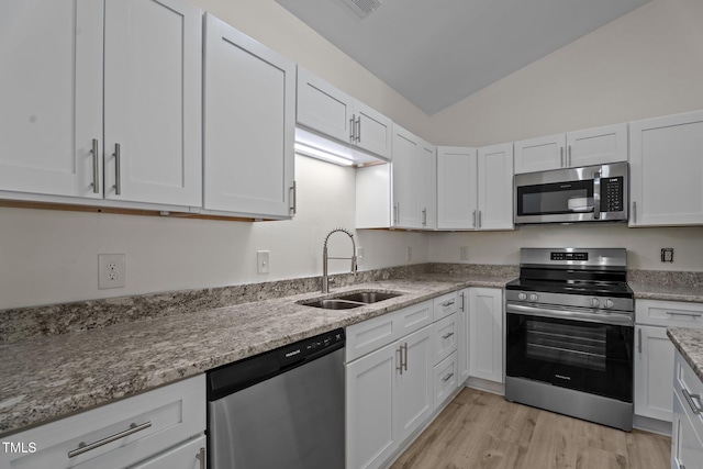 2941 Golden Oak Ct, Raleigh, NC 27603 - kitchen featuring a sink, white cabinets, vaulted ceiling, and stainless steel appliances