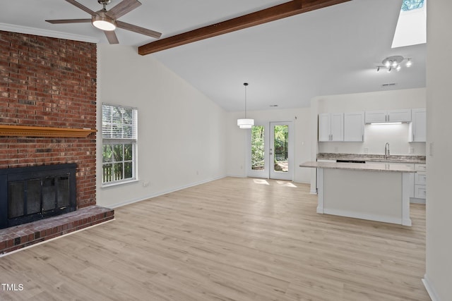 2941 Golden Oak Ct, Raleigh, NC 27603 - unfurnished living room featuring a healthy amount of sunlight, a sink, a ceiling fan, and lofted ceiling with beams