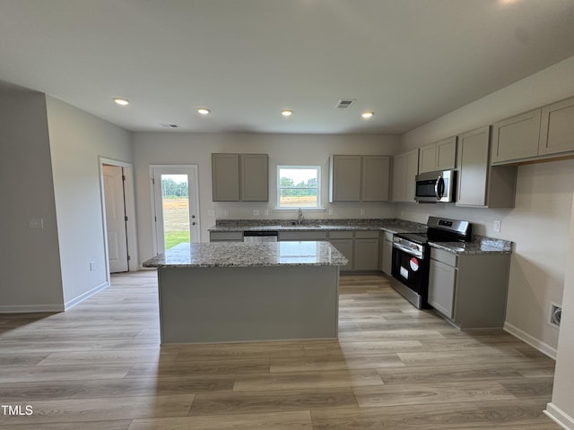 168 Bruce Dr, Dunn, NC 28334 - kitchen featuring appliances with stainless steel finishes, gray cabinets, a center island, light stone countertops, and recessed lighting