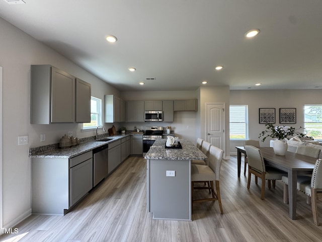168 Bruce Dr, Dunn, NC 28334 - kitchen featuring gray cabinetry, stainless steel appliances, recessed lighting, light stone countertops, and light wood-style floors