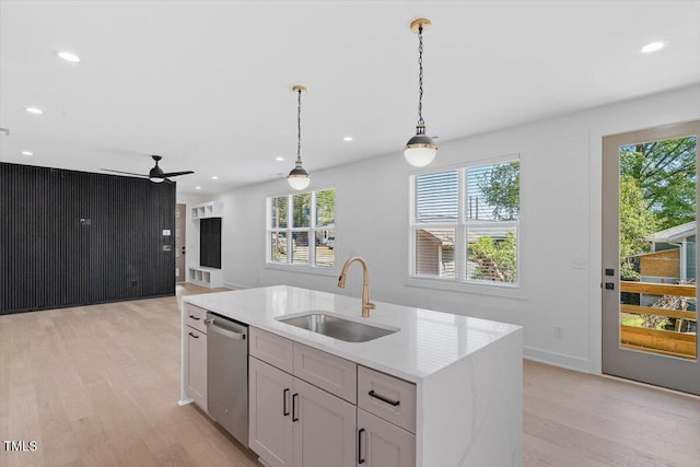 kitchen with ceiling fan, a sink, light wood finished floors, dishwasher, and decorative light fixtures