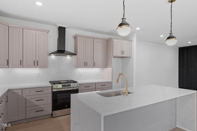 kitchen featuring recessed lighting, a sink, wall chimney exhaust hood, and stainless steel gas stove