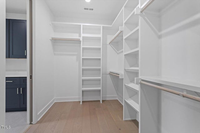 spacious closet featuring visible vents and light wood-style flooring