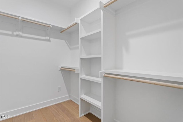 walk in closet with wood finished floors