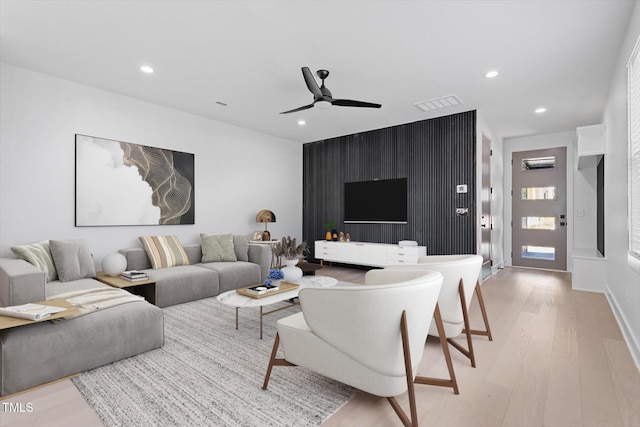 living area featuring light wood-type flooring, a ceiling fan, visible vents, and recessed lighting