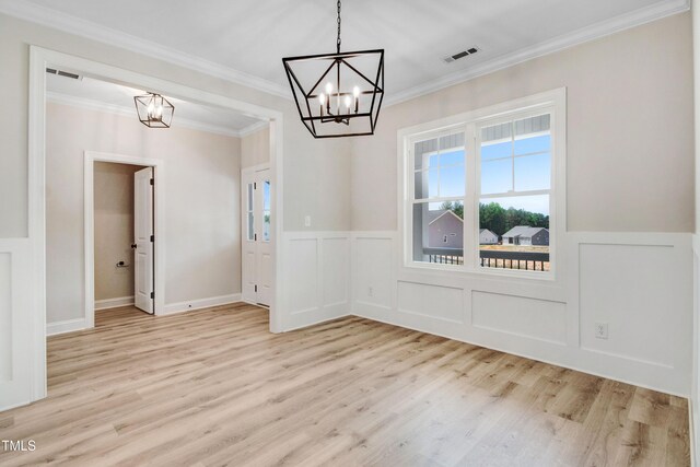 186 Gumtop Dr, Zebulon, NC 27597 - unfurnished dining area with a chandelier, light wood-type flooring, wainscoting, ornamental molding, and a decorative wall