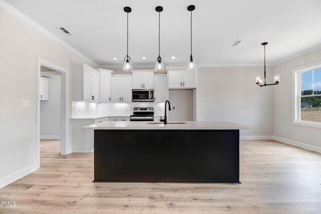 186 Gumtop Dr, Zebulon, NC 27597 - kitchen with stainless steel appliances, crown molding, a sink, light wood-style flooring, and white cabinetry